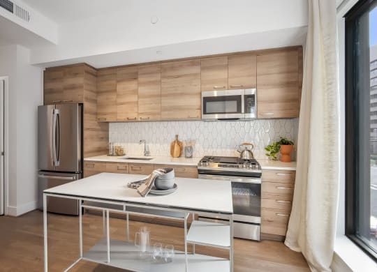 a kitchen with stainless steel appliances and a white table at The Grace and Reva, Arlington, Virginia