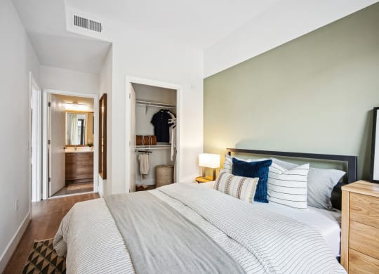 a bedroom with a large bed and a hallway to a bathroom at The Grace and Reva, Arlington, Virginia