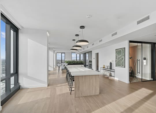 A modern kitchen with a large island and a view of the city.