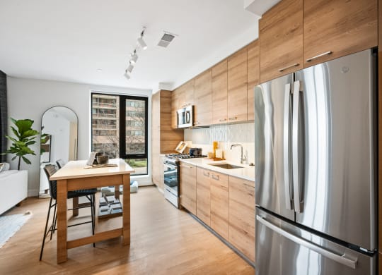 a kitchen with a stainless steel refrigerator and a wooden table at The Grace and Reva, Virginia, 22202