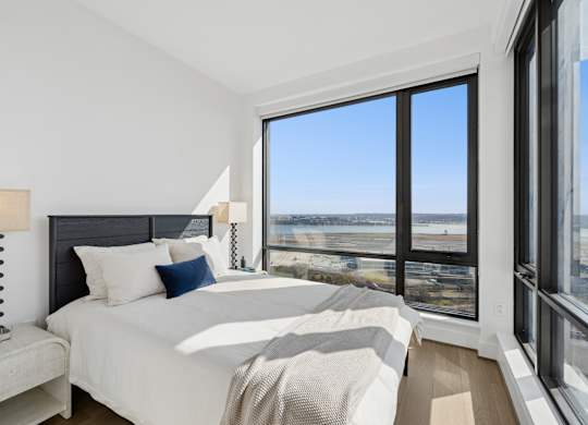 A bedroom with a large bed and a view of the city.