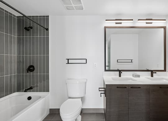 A white toilet sits next to a white sink in a bathroom.