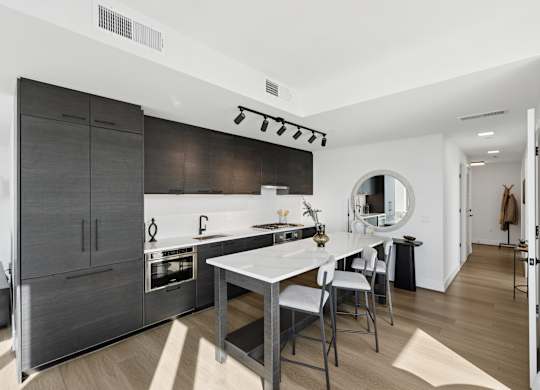 A modern kitchen with a large island and a dining table.