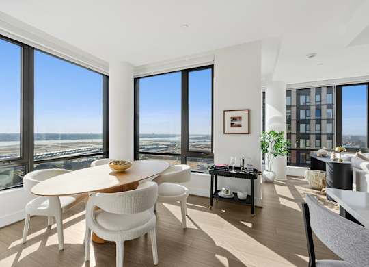 A modern dining room with a round table and chairs.