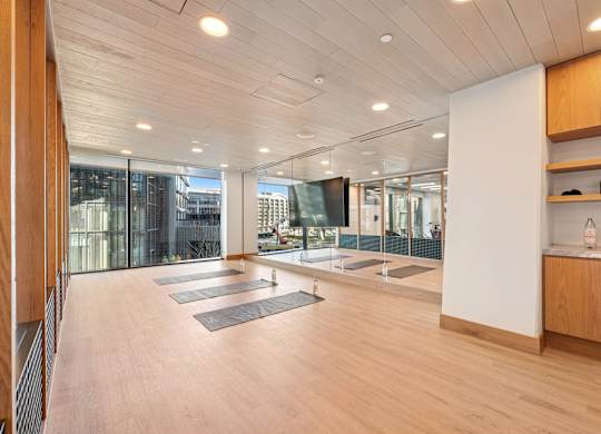 A yoga studio with wooden floors and mirrors on the wall.