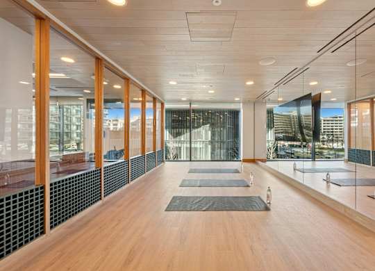 A yoga studio with wooden floors and mirrors on the wall.