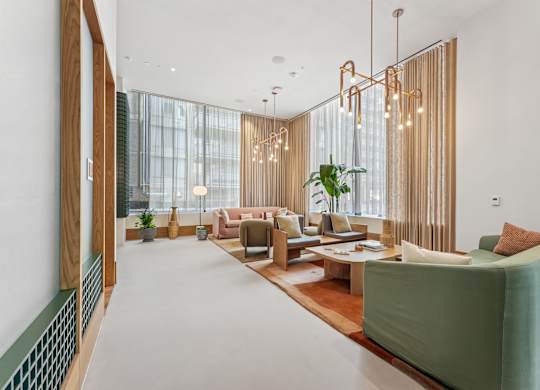 A lobby with a green sofa and a wooden floor.