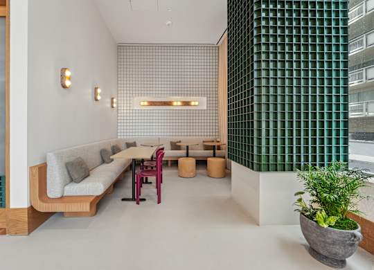 A modern living room with a long couch and a green wall.