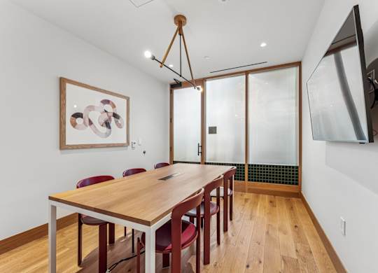 A dining room with a wooden table and chairs.