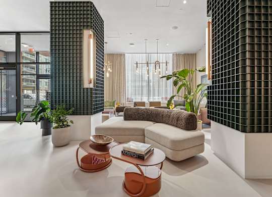 A modern living room with a white couch, a brown coffee table, and a green wall.
