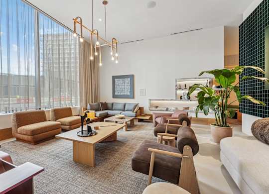 A modern living room with a large window and a variety of seating options.