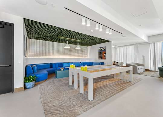 A modern living room with a blue sofa and a white coffee table.