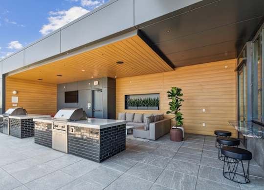 A modern outdoor seating area with a wooden exterior and a glass wall.