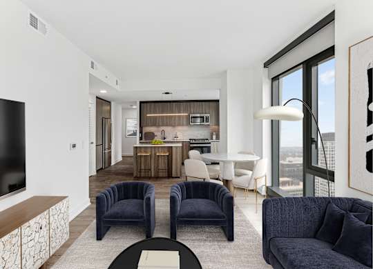 A modern living room with a television, two chairs, and a dining table.
