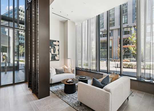 A modern living room with a large window and a white couch.