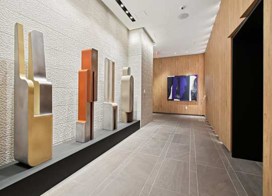 A hallway with a series of metallic sculptures on display.