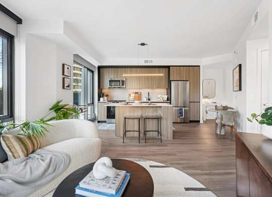 A modern kitchen with a breakfast bar and a dining table with chairs.