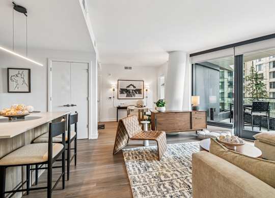 A modern living room with a dining area and a view of a building outside.