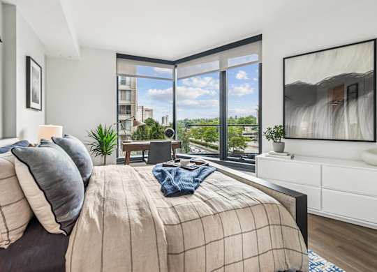 A bedroom with a large bed and a view of the city.