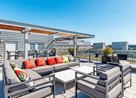 a roof deck with couches and chairs and a table