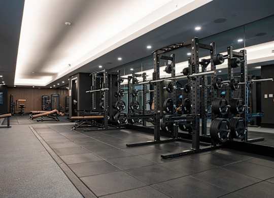 A gym with a variety of weightlifting equipment.