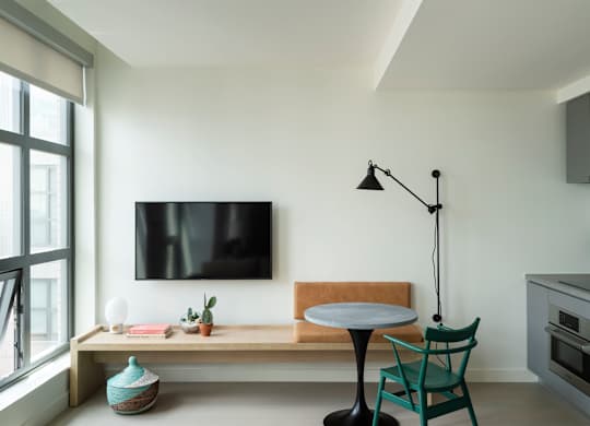A modern living room with a flat screen TV mounted on the wall.