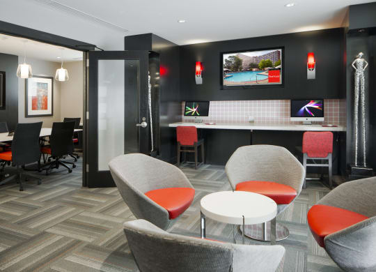 a lounge area with chairs and tables and a television