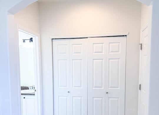 A white double door is in a white archway.