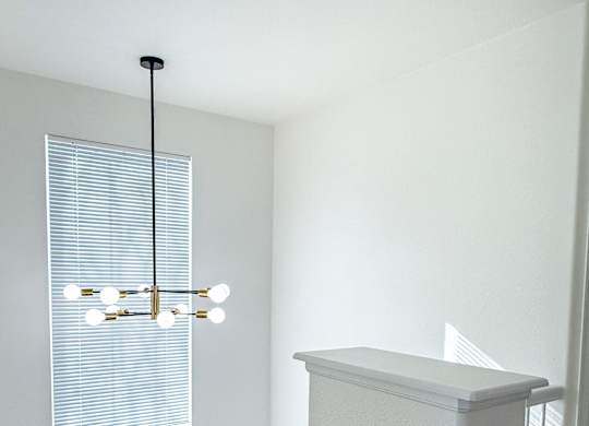 A white staircase with a light hanging from the ceiling.