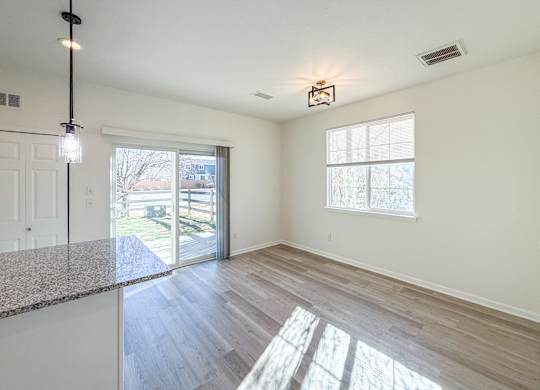 A sunny day in a spacious room with a marble countertop and a window.
