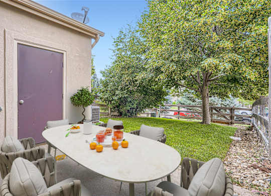 A table with chairs and oranges on it.