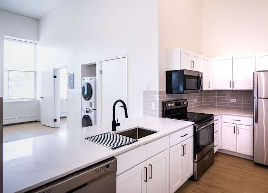 A kitchen with white cabinets and stainless steel appliances.
