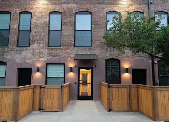 A building with a brown brick facade and a wooden fence in front.