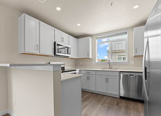 White Cabinetry And Appliances In Kitchen at The Townhomes at Pine Drive, Parker, CO, Colorado, 80138