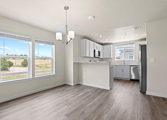 Kitchen with white cabinets and a wooden floor at The Townhomes at Pine Drive, Parker, 80138