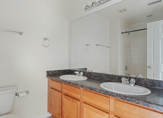 A white bathroom with a tub, sink, and mirror.