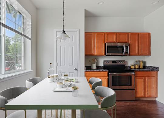A modern kitchen with a dining table set for six.