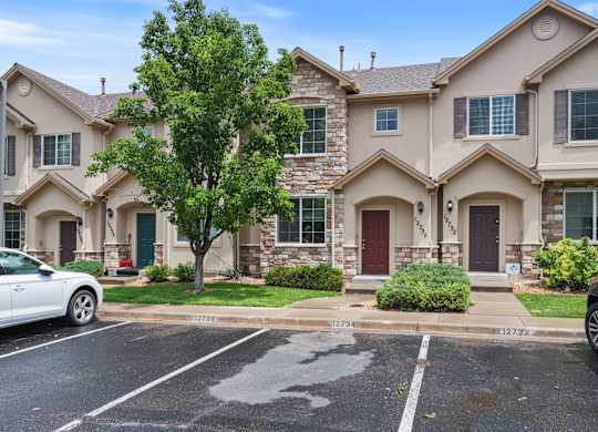 A row of houses with a car parked in front of them.