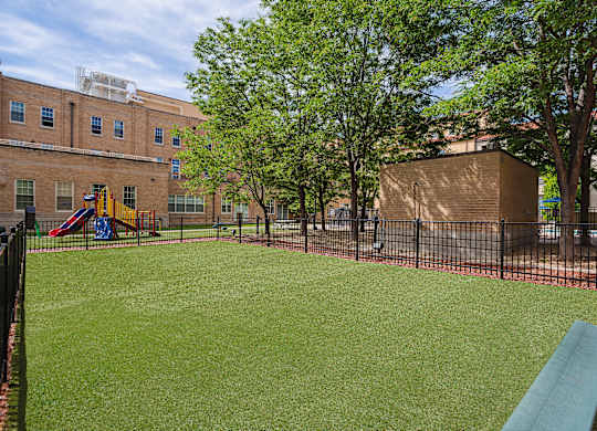 A playground with a green slide and a red slide.