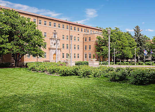A large building with a green lawn in front.