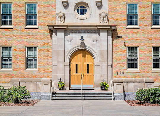 A large building with a yellow door and windows on the side.