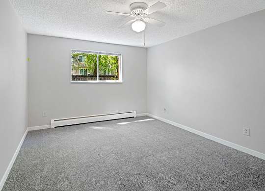 A room with a ceiling fan and a window.