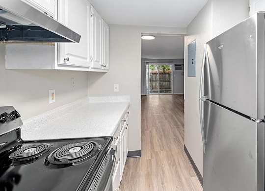 A kitchen with a black stove top and a white counter top.
