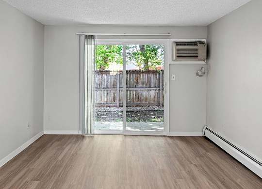 A room with a sliding glass door leading to a backyard.