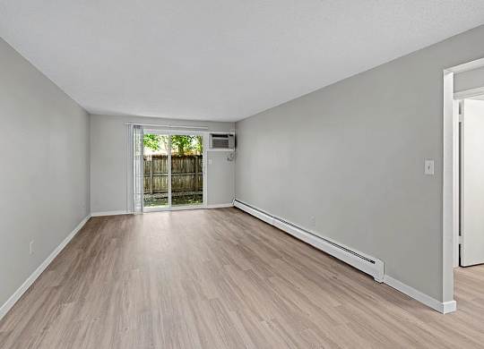 A room with light wood flooring and white walls.