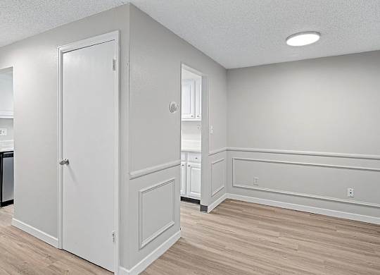 A white door is in a room with wood flooring.