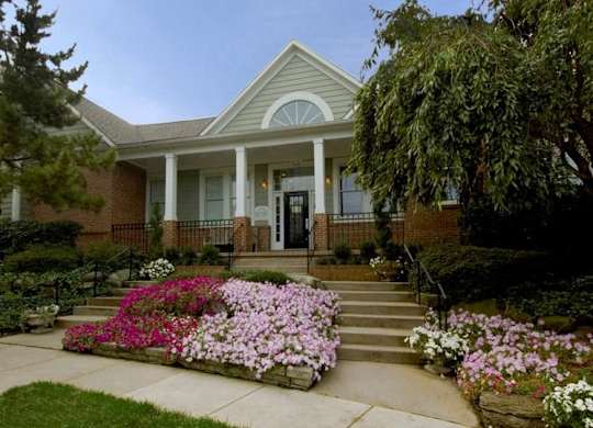 A house with a front porch and a flower bed in front.