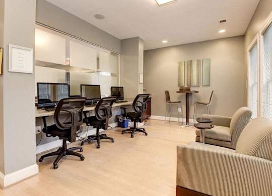 A room with a desk, chairs, and a couch.