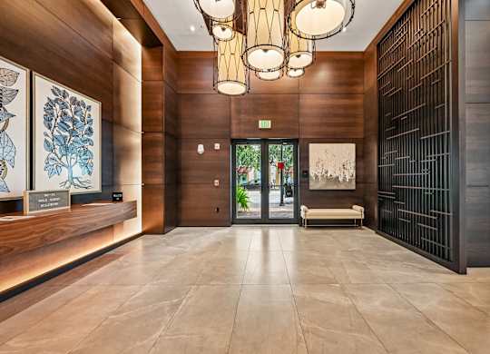 A hallway with a wooden floor and a black gate on the right side.