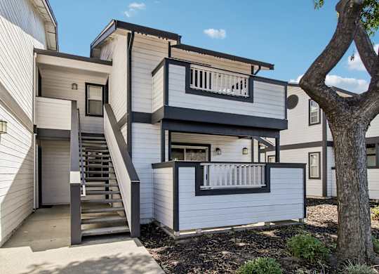 A modern two-story house with a staircase leading to the upper level.